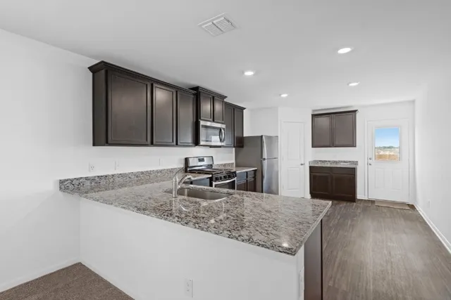 a kitchen with granite countertop a sink and a stove top oven