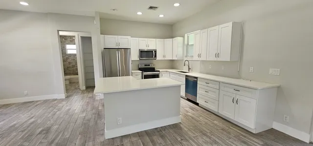 a kitchen with white cabinets and stainless steel appliances
