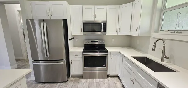 a kitchen with refrigerator a stove and cabinets