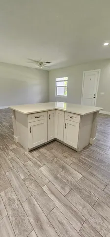 a view of a kitchen with cabinets and wooden floor