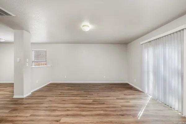a view of an empty room with wooden floor