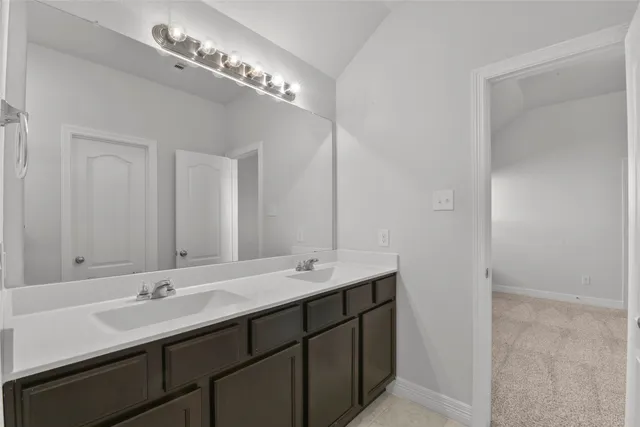a bathroom with double vanity and a mirror
