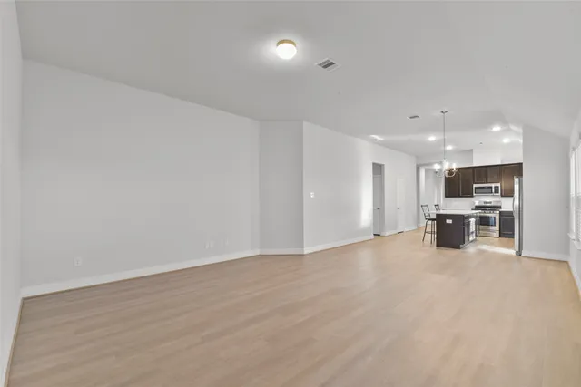 a view of an empty room with wooden floor