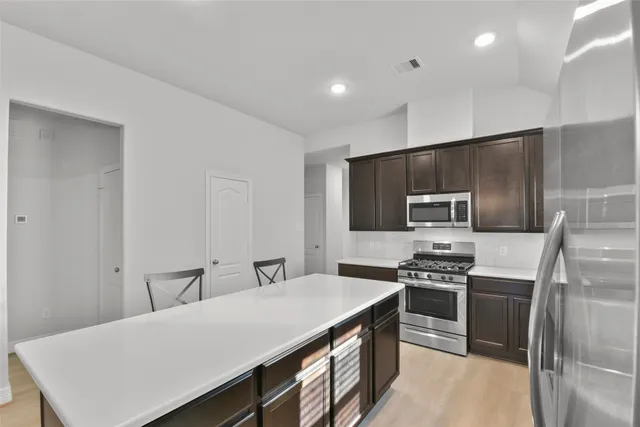 a kitchen with a stove a sink and a refrigerator