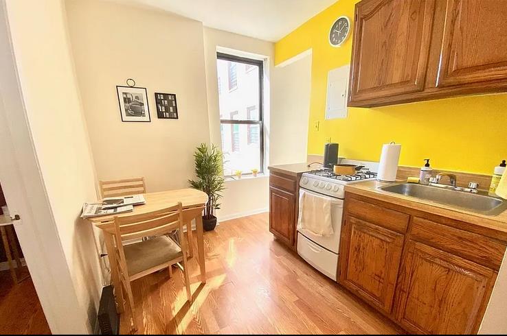 a kitchen with stainless steel appliances granite countertop a stove a sink and a refrigerator with wooden floors