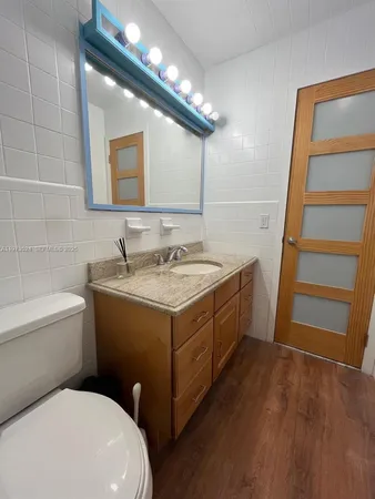 a bathroom with a sink a toilet and mirror
