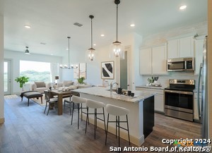 289 Star Grass, Unit B Spring Branch, TX 78070 - Photo 1 of 1 a kitchen with stainless steel appliances granite countertop a stove a sink a kitchen island a stove and a wooden floors