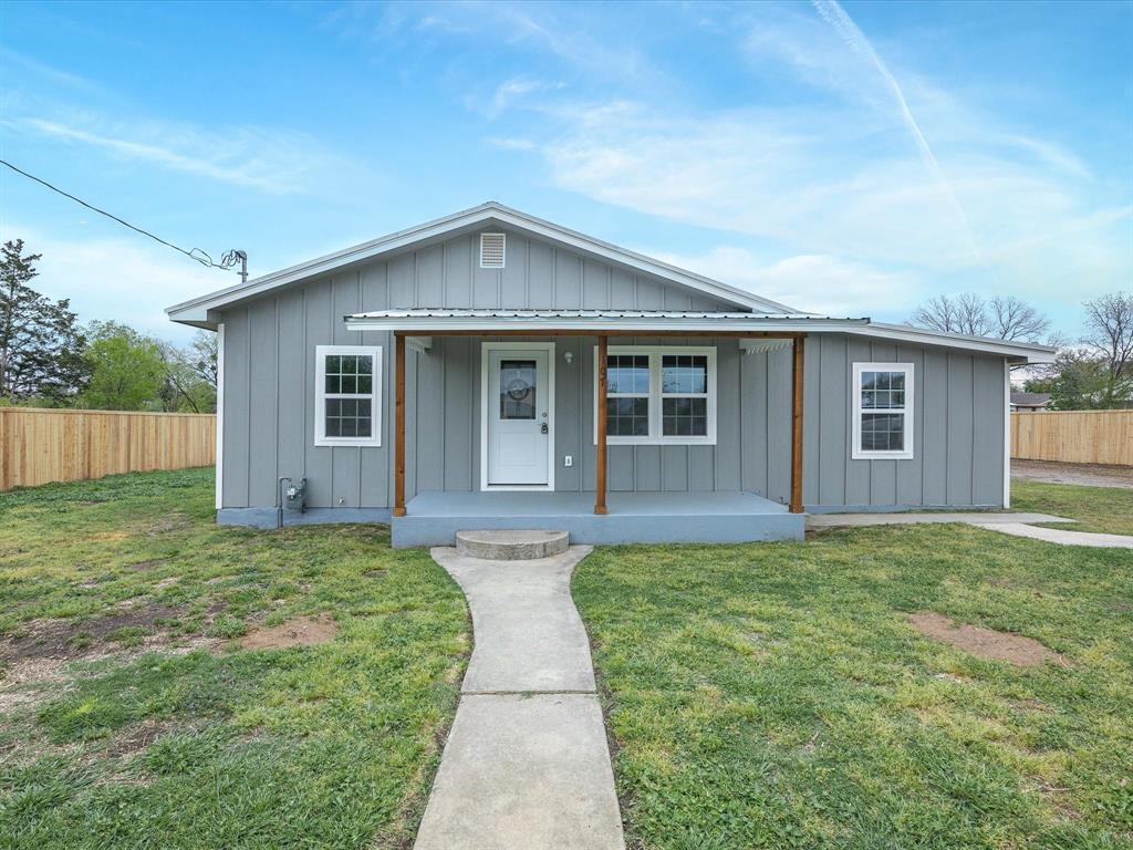 Bungalow-style house featuring a front yard, a porch, fence, and board and batten siding