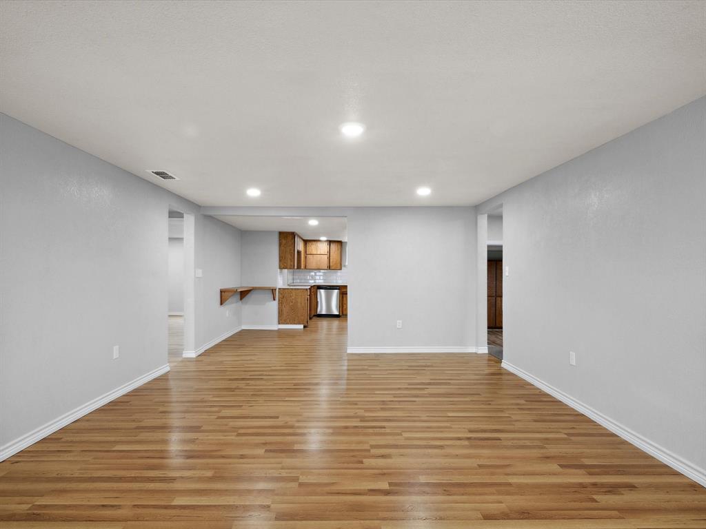 107 East Riley Street Bowie, TX 76230 - Photo 14 of 32 Unfurnished living room with light wood-style flooring, baseboards, and visible vents