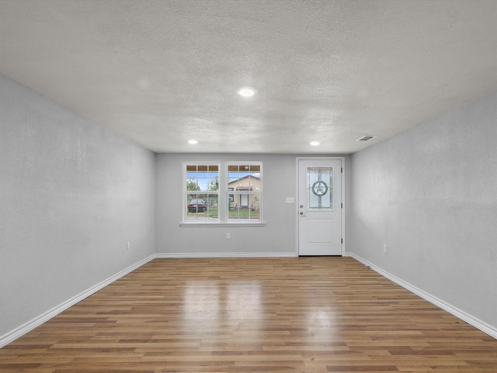 107 East Riley Street Bowie, TX 76230 - Photo 17 of 32 Entrance foyer featuring recessed lighting, a textured ceiling, baseboards, and wood finished floors