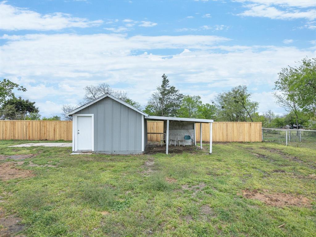 107 East Riley Street Bowie, TX 76230 - Photo 29 of 32 View of outbuilding featuring an outbuilding and fence