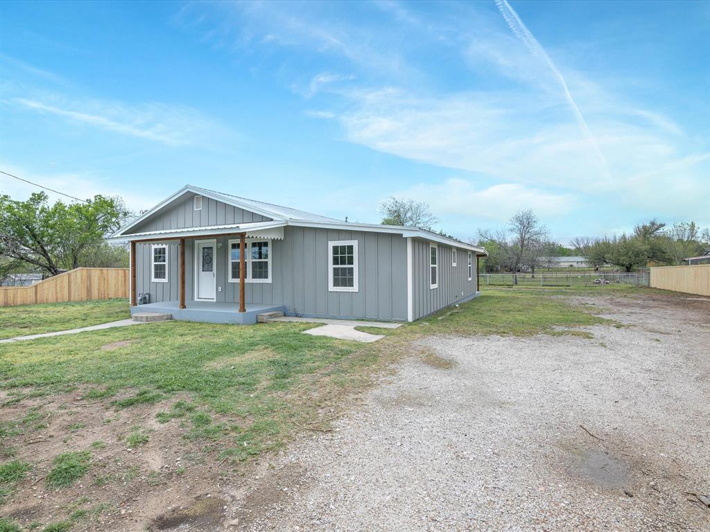 107 East Riley Street Bowie, TX 76230 - Photo 4 of 32 View of front of home featuring fence, board and batten siding, a porch, and a front yard