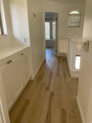 a view of a hallway with wooden floor and staircase