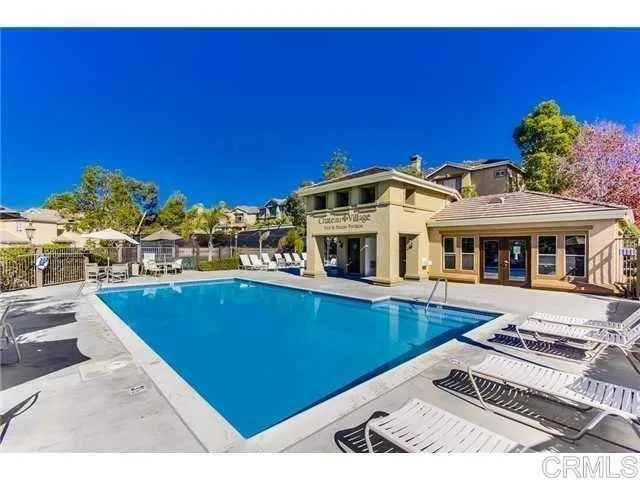 a view of a house with pool and chairs