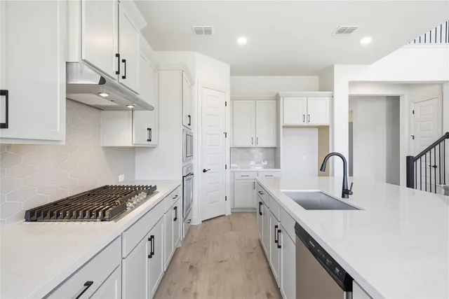 a kitchen with a sink a stove and cabinets