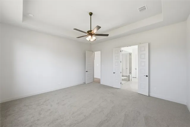 a view of an empty room with kitchen and window