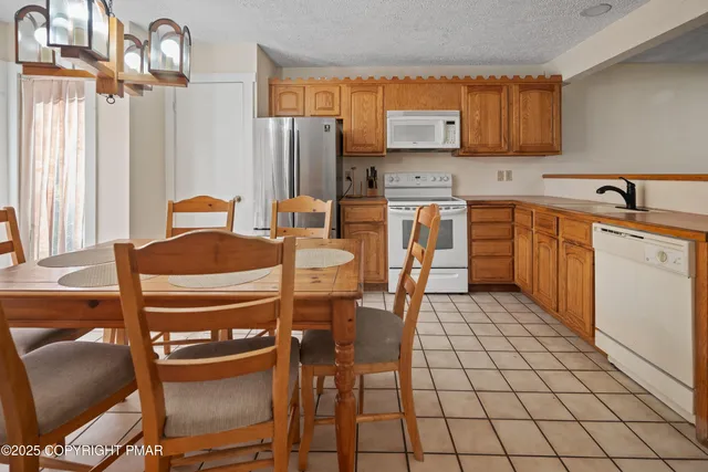 a kitchen with stainless steel appliances a stove a refrigerator and a dining table