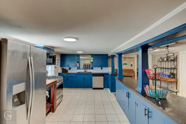 a kitchen with stainless steel appliances granite countertop a refrigerator and a stove