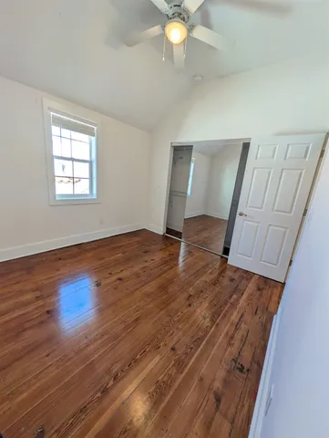 a kitchen with a refrigerator stove and wooden floor
