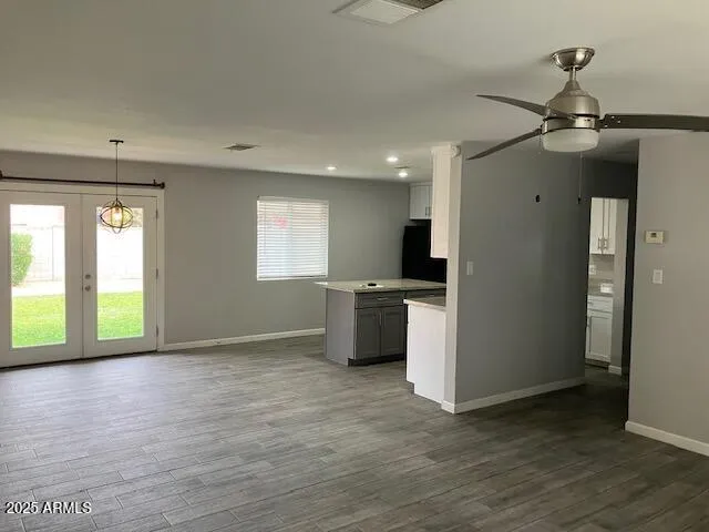 a view of empty room with wooden floor and windows