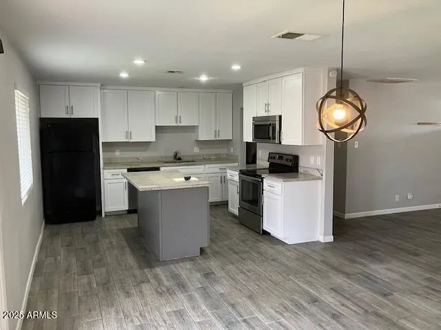 a kitchen with a refrigerator a microwave oven a sink and cabinets