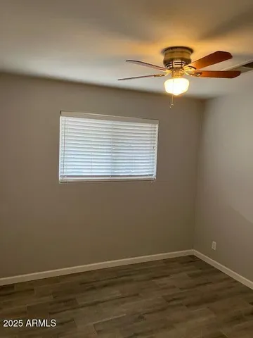 a view of a room with wooden floor and fan