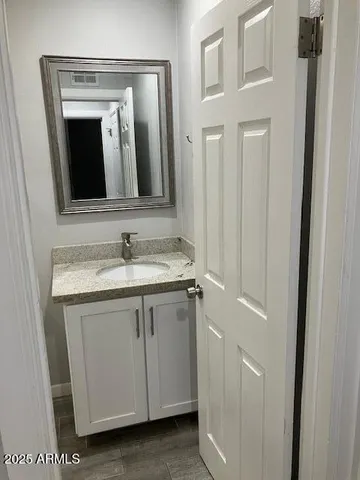 a bathroom with a granite countertop sink and a mirror