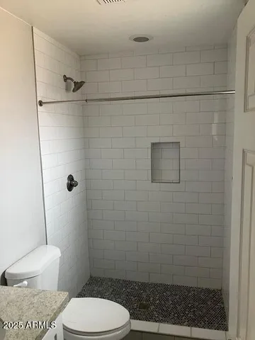 a bathroom with a toilet and a shower