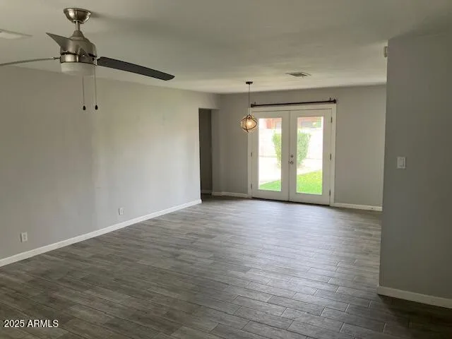 a view of an empty room with a window and wooden floor