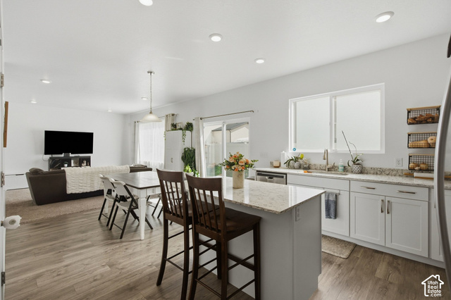 1113 South Raintree Lane Santaquin, UT 84655 - Photo 22 of 59 Open-concept kitchen and living area featuring wood-finish flooring, recessed lighting, white cabinetry, and light-toned countertops