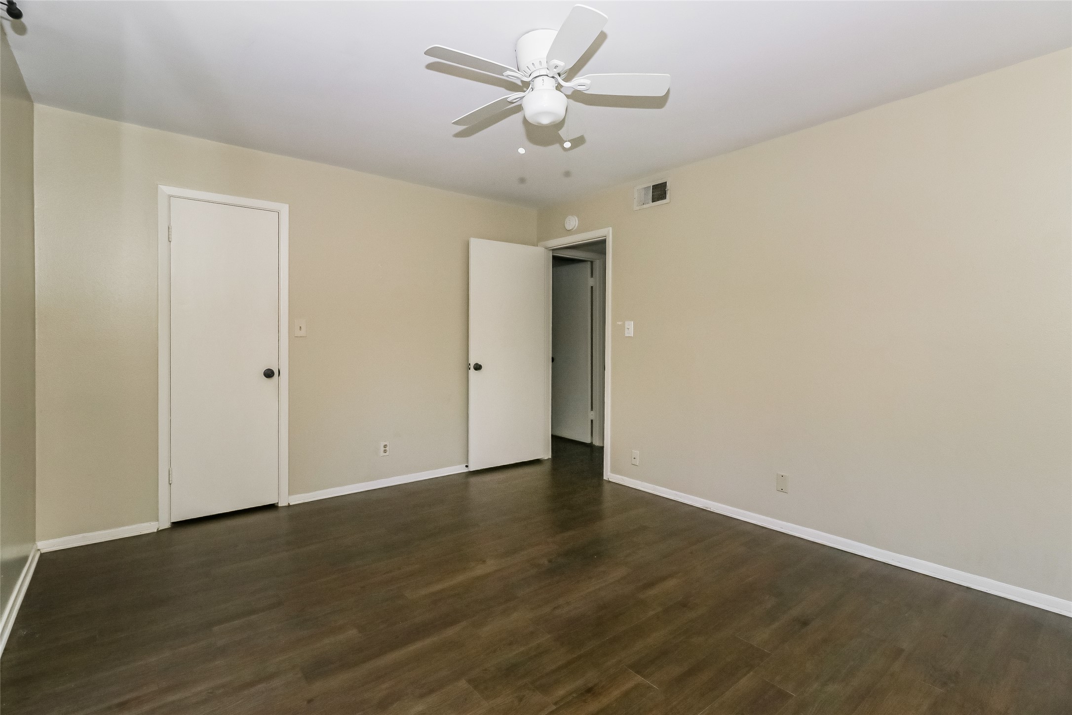 500 East Riverside Drive, Unit 135 Austin, TX 78704 - Photo 12 of 16 Unfurnished bedroom featuring ceiling fan and dark wood-style flooring
