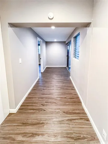 a view of a hallway with wooden floor
