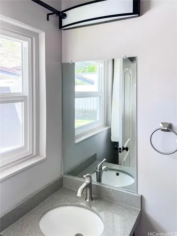 a bathroom with a sink a toilet and a mirror