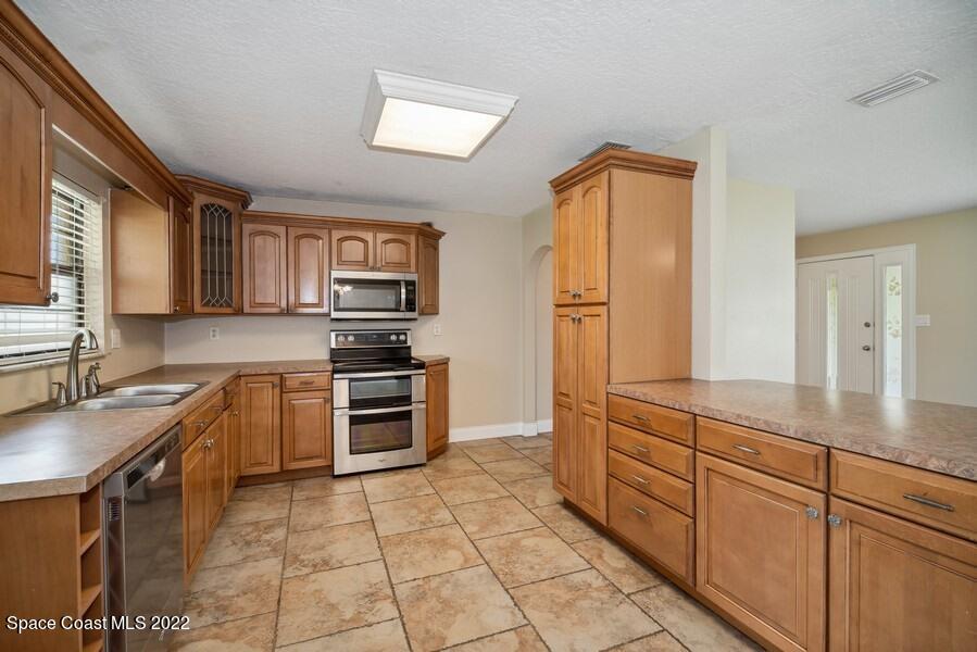 1840 Britt Road Cocoa, FL 32926 - Photo 2 of 17 a kitchen with stainless steel appliances granite countertop a sink stove and cabinets
