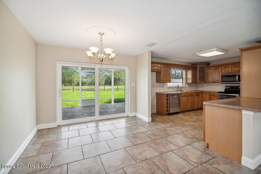 1840 Britt Road Cocoa, FL 32926 - Photo 5 of 17 a kitchen with stainless steel appliances a stove a sink a microwave a refrigerator and cabinets
