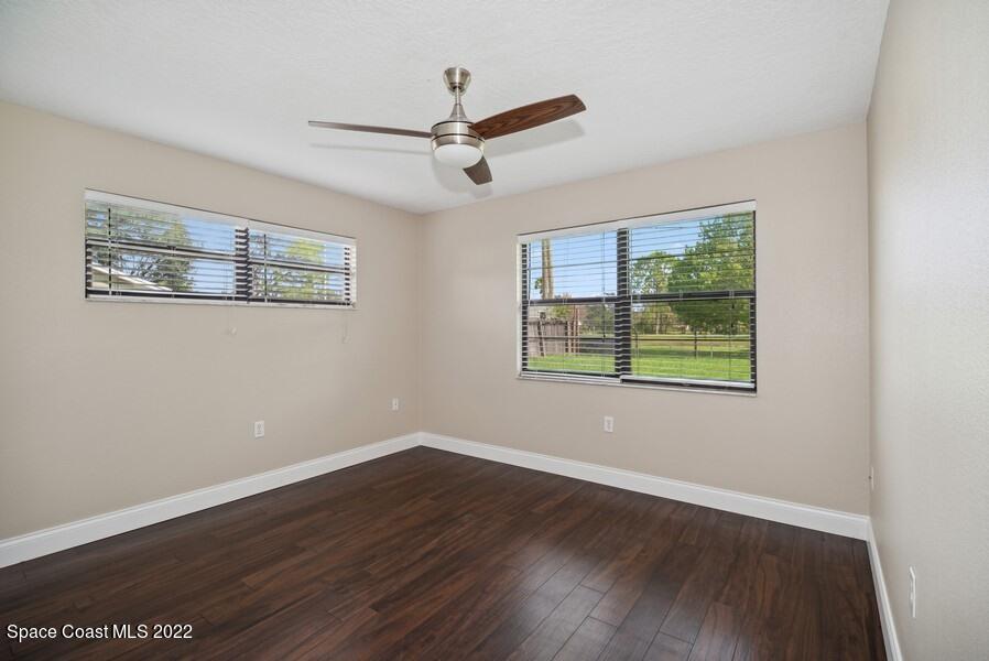1840 Britt Road Cocoa, FL 32926 - Photo 10 of 17 a view of a room with wooden floor ceiling fan and windows