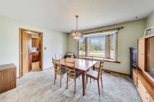 a dining room with furniture a chandelier and wooden floor