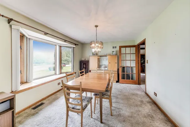 a dining room with furniture window and wooden floor