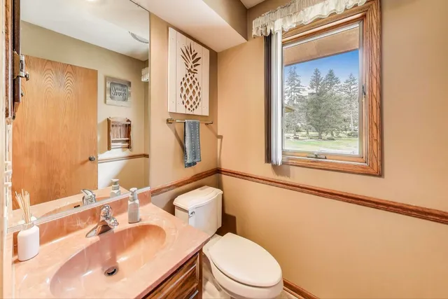 a bathroom with a sink mirror vanity and toilet