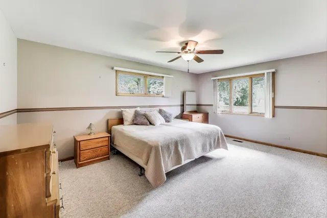 a spacious bedroom with a bed and a chandelier