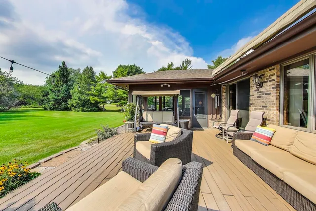 a view of a patio with couches chairs and wooden floor