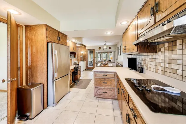a kitchen with stainless steel appliances granite countertop a refrigerator a stove and a sink