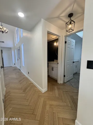 a view of an empty room with window and a kitchen