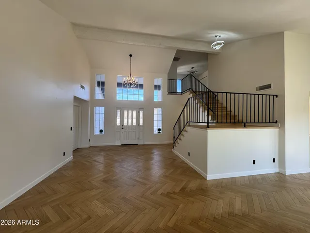 a view of empty room with windows and ceiling fan