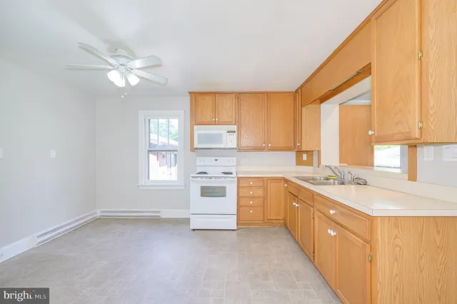a kitchen with granite countertop a sink stove and cabinets