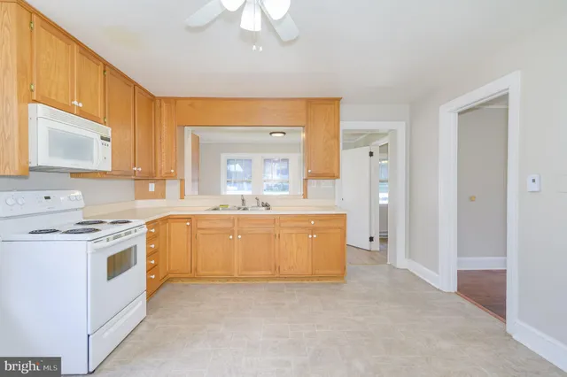 a large kitchen with kitchen island a sink stainless steel appliances and cabinets