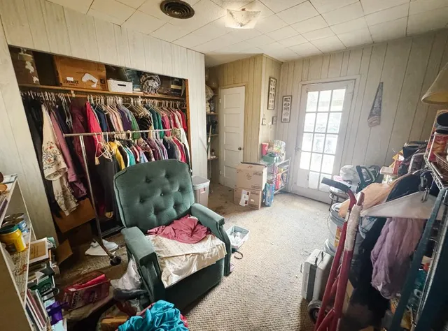 a living room with lots of furniture and clothes
