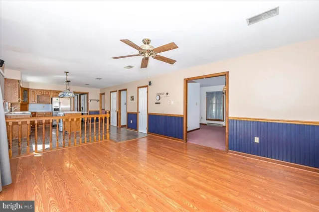 a living room with stainless steel appliances granite countertop furniture wooden floor and a large window