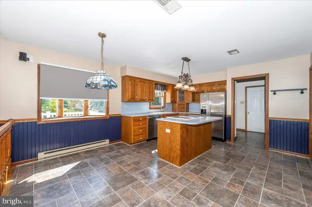 a kitchen with stainless steel appliances granite countertop a sink and a refrigerator