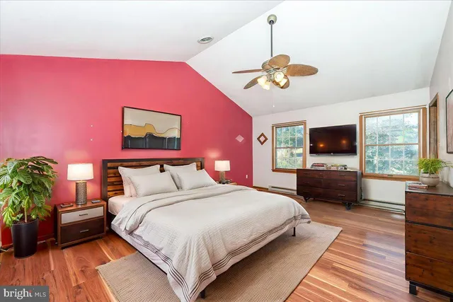 a bedroom with a bed a flat screen tv and a couch